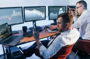 Money investment. Two stock traders working in the office with exchange technology